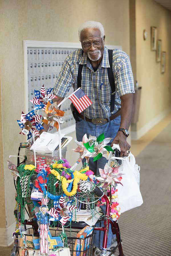 Senior black man with a push cart full of veterans day trinklets - St. John Towers Photo Gallery